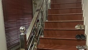 Una escalera con barandilla de metal y escalones de madera.