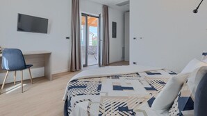 A modern bedroom with a bed, a desk, and a chair.