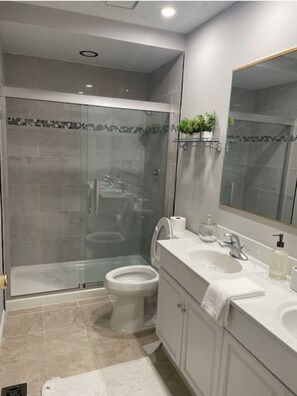 Een douche, handdoeken, zeep, toiletpapier