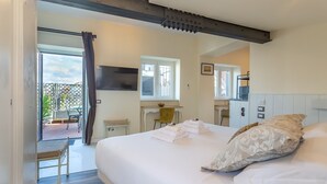 Une chambre avec un grand lit, un bureau, une chaise et une fenêtre.