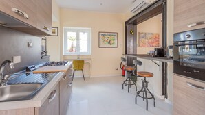Une cuisine moderne dotée d’appareils électroménagers en acier inoxydable, d’un coin bar et d’une fenêtre laissant entrer la lumière naturelle.