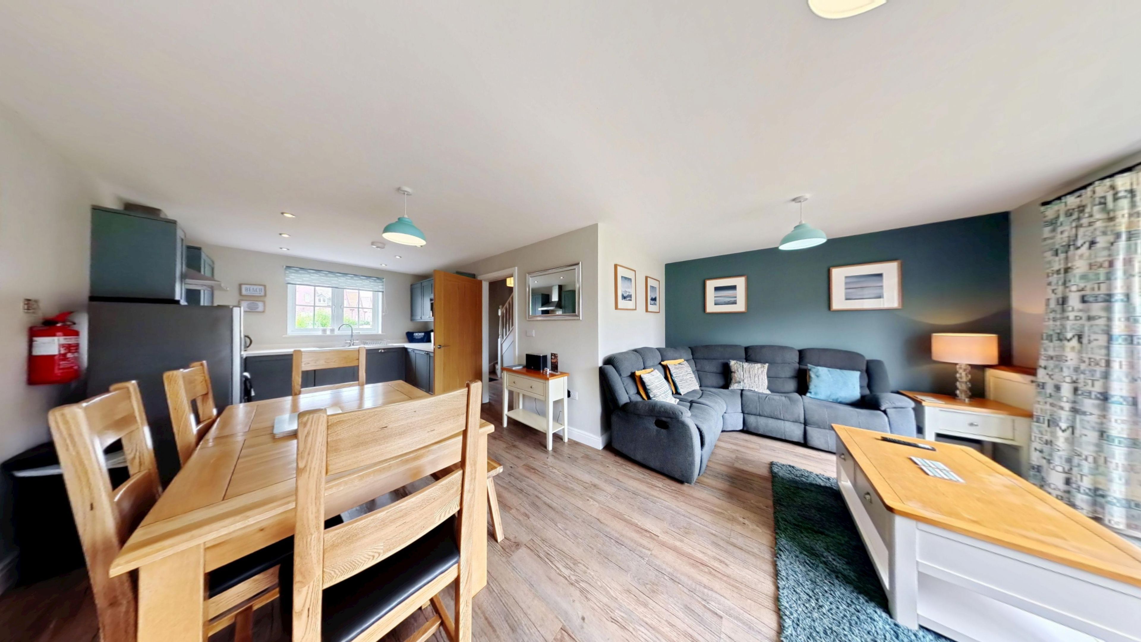 A modern living space with a dining area, kitchen, and seating area.