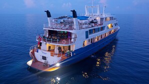 A large cruise ship with multiple decks, outdoor seating areas, and a lifebuoy visible on the side. - Yasawa Princess (Malé)
