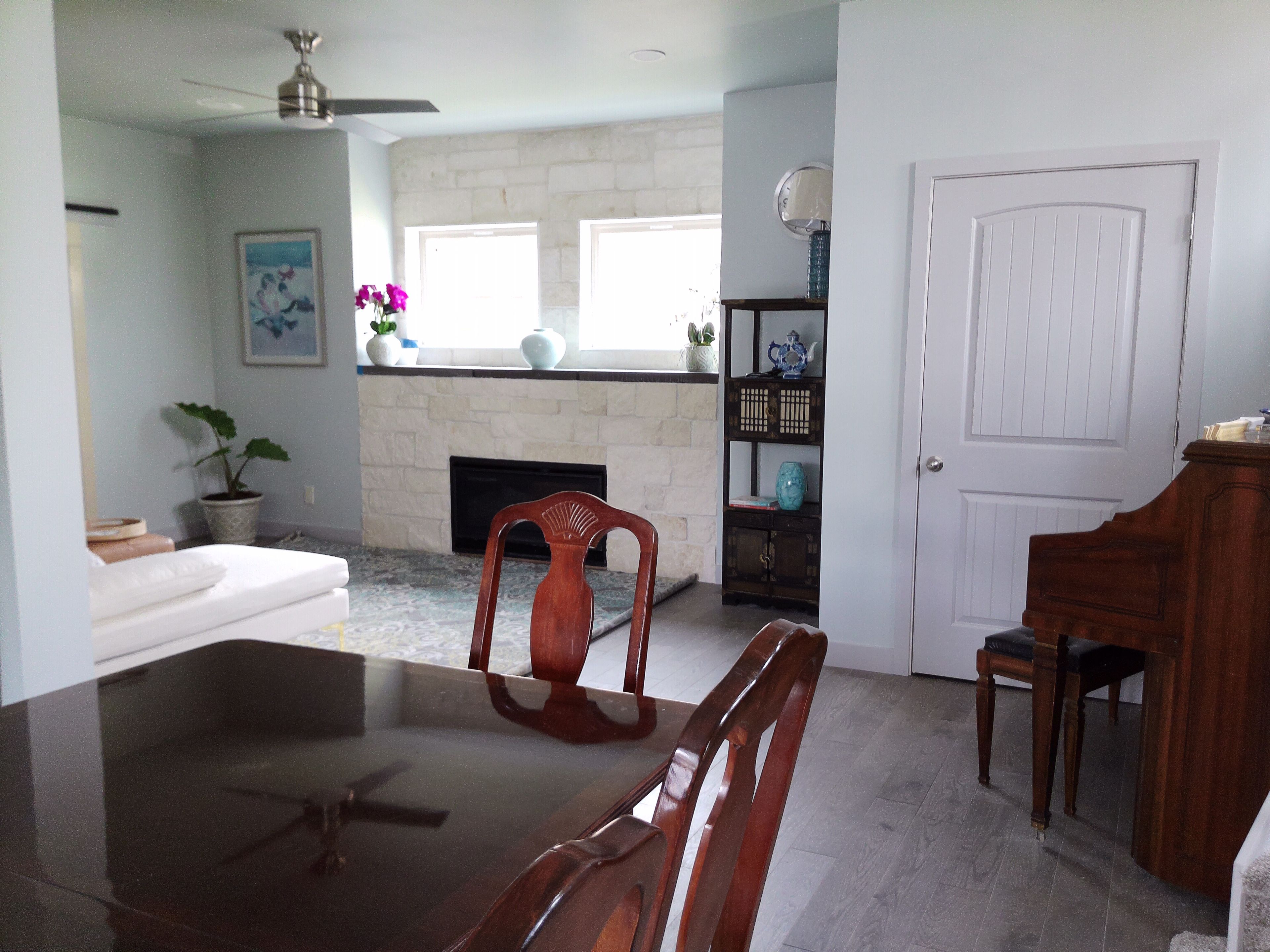 A dining area with a table and chairs, a fireplace, a bookshelf, and a door.