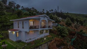 A two-story house with a balcony, surrounded by greenery and hills. - Peri Resorts by Indostays (Kotagiri)