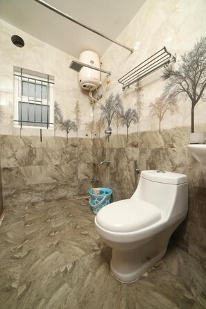 Une salle de bain avec des toilettes, une douche et un lavabo.