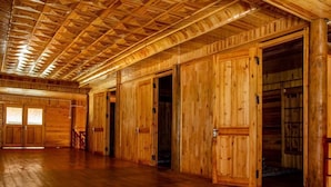 Un intérieur spacieux en bois, avec de hauts plafonds et de grandes portes en bois.