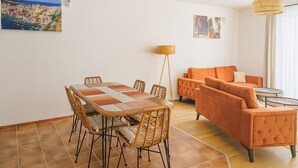 Un coin repas comprenant une table et des chaises, un canapé et une lampe sur pied.