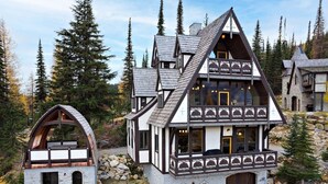 A traditional chalet with a stone foundation, wooden upper structure, and a prominent gabled roof. - Ski-In/Ski-Out Schweitzer Chalet + Private Hot Tub - Guest Favorite (Sandpoint)