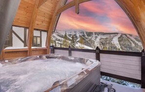 Tinaco con cubierta de madera y vista a un paisaje montañoso nevado.
