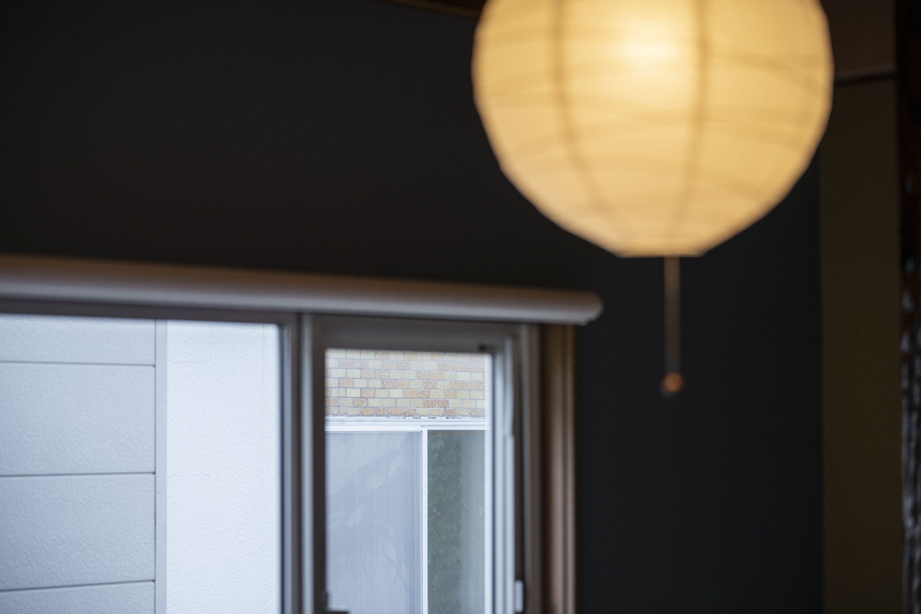 A room with a window, a door, and a hanging light fixture.