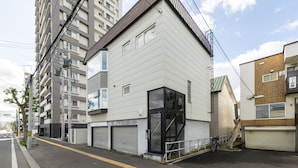 Un bâtiment moderne à deux étages, doté d’un toit plat, de grandes fenêtres et d’une porte de garage.