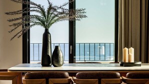 A dining area with a table, chairs, a vase with branches, and candles. - Beach Villas in Crete Alope & Ava (Ierapetra)
