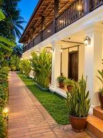 A hotel with a covered walkway, potted plants, and a well-lit entrance.