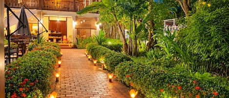 A pathway lined with lanterns leading to a building with a traditional architectural style.