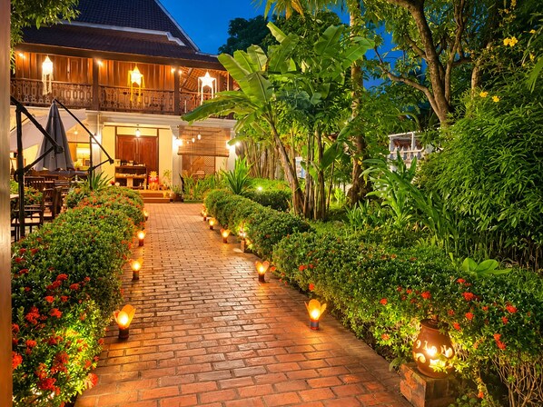 A pathway lined with lanterns leading to a building with a traditional architectural style.