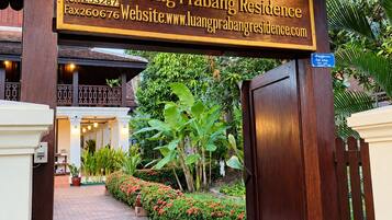 A wooden sign with contact information for Luang Prabang Residence.