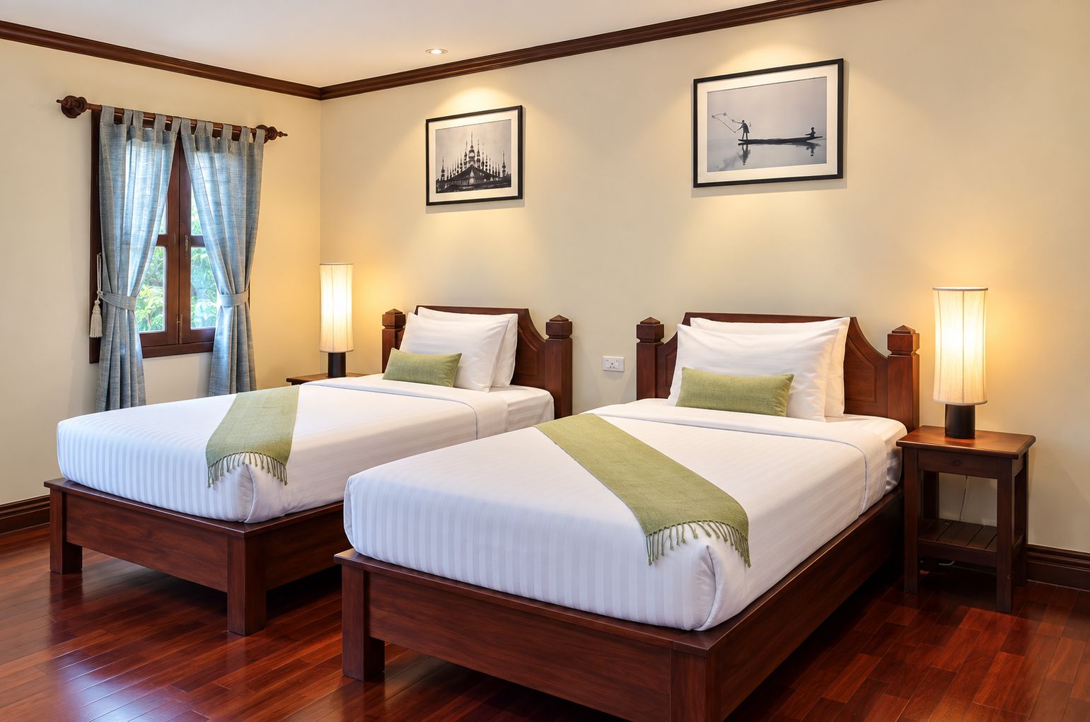 A hotel room with two beds, wooden headboards, and bedside lamps.
