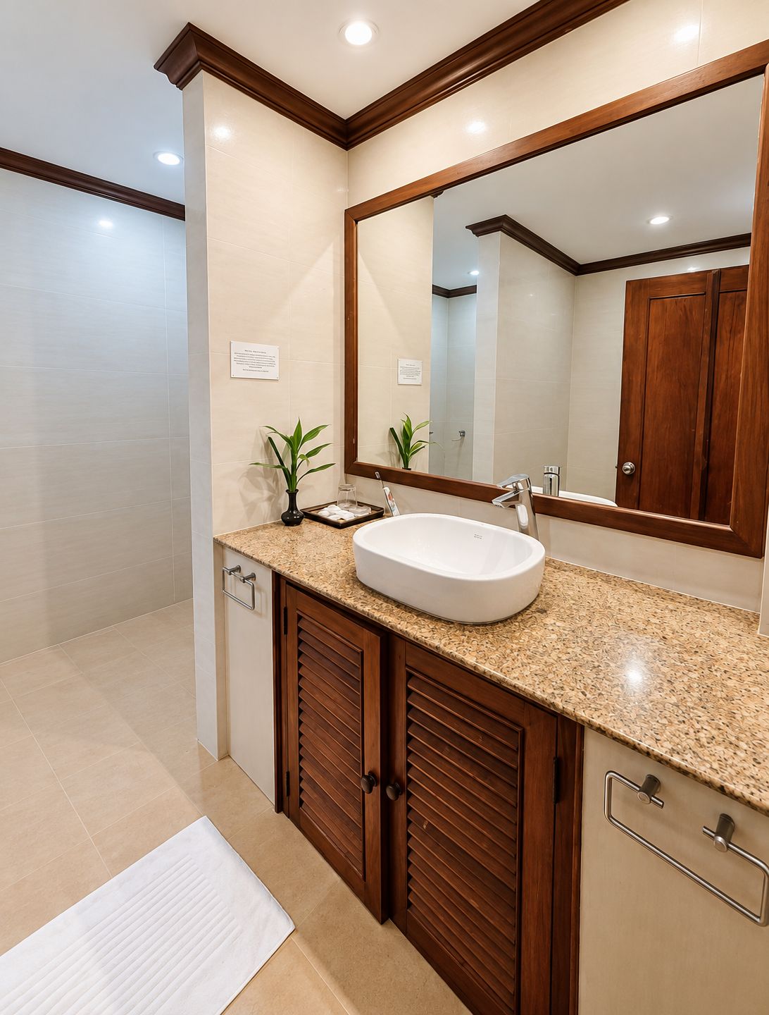 Une salle de bain avec un grand miroir, un lavabo et des meubles en bois.