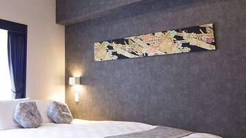 A hotel room with a large bed, two pillows, a textured wall, and a decorative wall hanging.