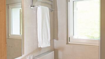 A modern bathroom with a white sink, mirror, and toilet.