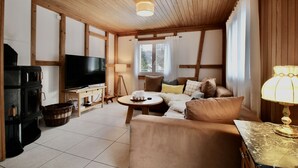 A cozy living room with a fireplace, a television, a sofa, and a lamp.