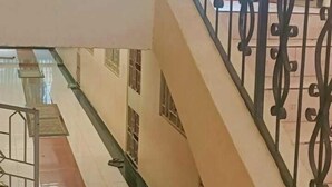 A multi-level building with a staircase, metal railings, and a tiled floor.