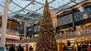 A large indoor Christmas tree in a shopping mall with a glass ceiling and multiple stores. - Lovely 2-bed Studio10 in Coventry (Coventry)