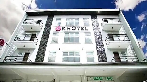 A hotel with a modern facade, balconies, and a sign for 'SOAK N GO' at the entrance. - Khotel near T3 Airport (Pasay)