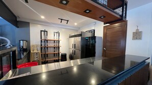 A modern kitchen with stainless steel appliances, a wooden countertop, and a glass backsplash. - Khotel near T3 Airport (Pasay)
