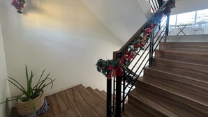 A staircase with wooden steps and a metal railing, decorated with a garland. - Khotel near T3 Airport (Pasay)