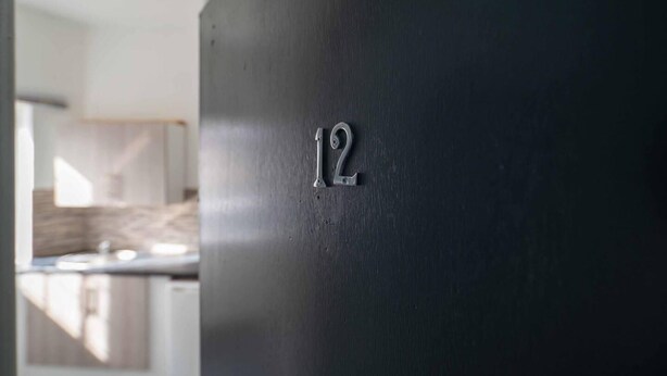 A close-up of a dark wall with the number '12' embossed on it. - Impeccable Flat 1-bed Studio12 in Coventry (Coventry)