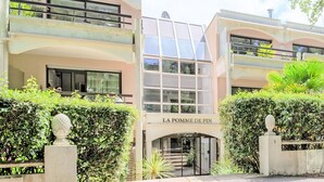 Un hôtel à la façade moderne, doté de grandes fenêtres et d’une enseigne indiquant « LA POMME DE PIN ».