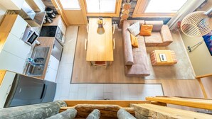 Un espace de vie compact comprenant une cuisine, un coin repas et un coin salon.