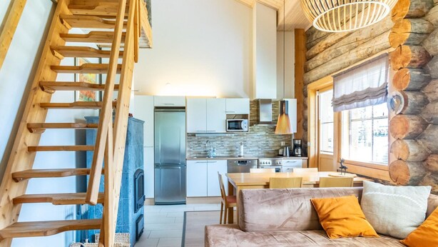 Un salon chaleureux avec un escalier en bois, un canapé agrémenté de coussins orange et une cheminée.