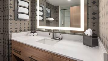 A bathroom with a marble sink, a large mirror, and a towel rack.