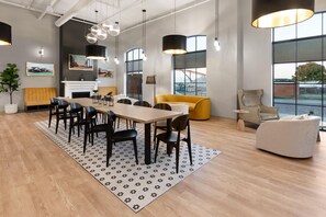 Een modern interieur met een eethoek, banken en grote ramen.