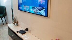 Een flatscreen televisie bevestigd aan een muur boven een witte console met lades.