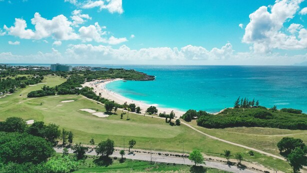 A coastal landscape with a beach, golf course, and ocean. - A-405 Stunning one bedroom apartment overlooking the pool (Cupecoy)