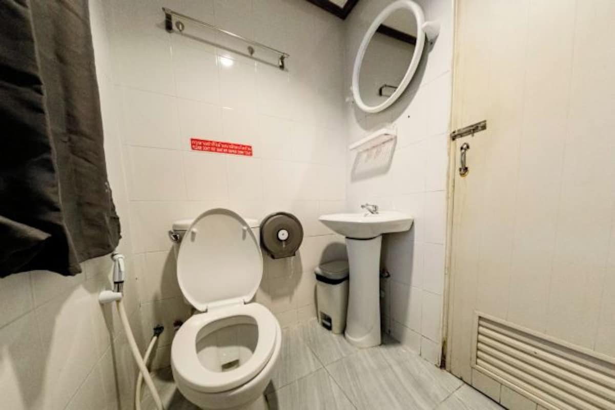 A small, clean bathroom with a toilet, sink, and mirror.