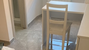 Une pièce comprenant un lit, une chaise et une table.