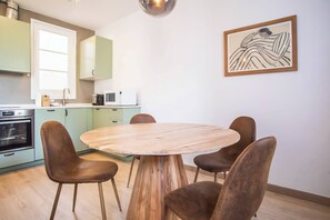 Une cuisine moderne avec une table ronde en bois et quatre chaises marron.