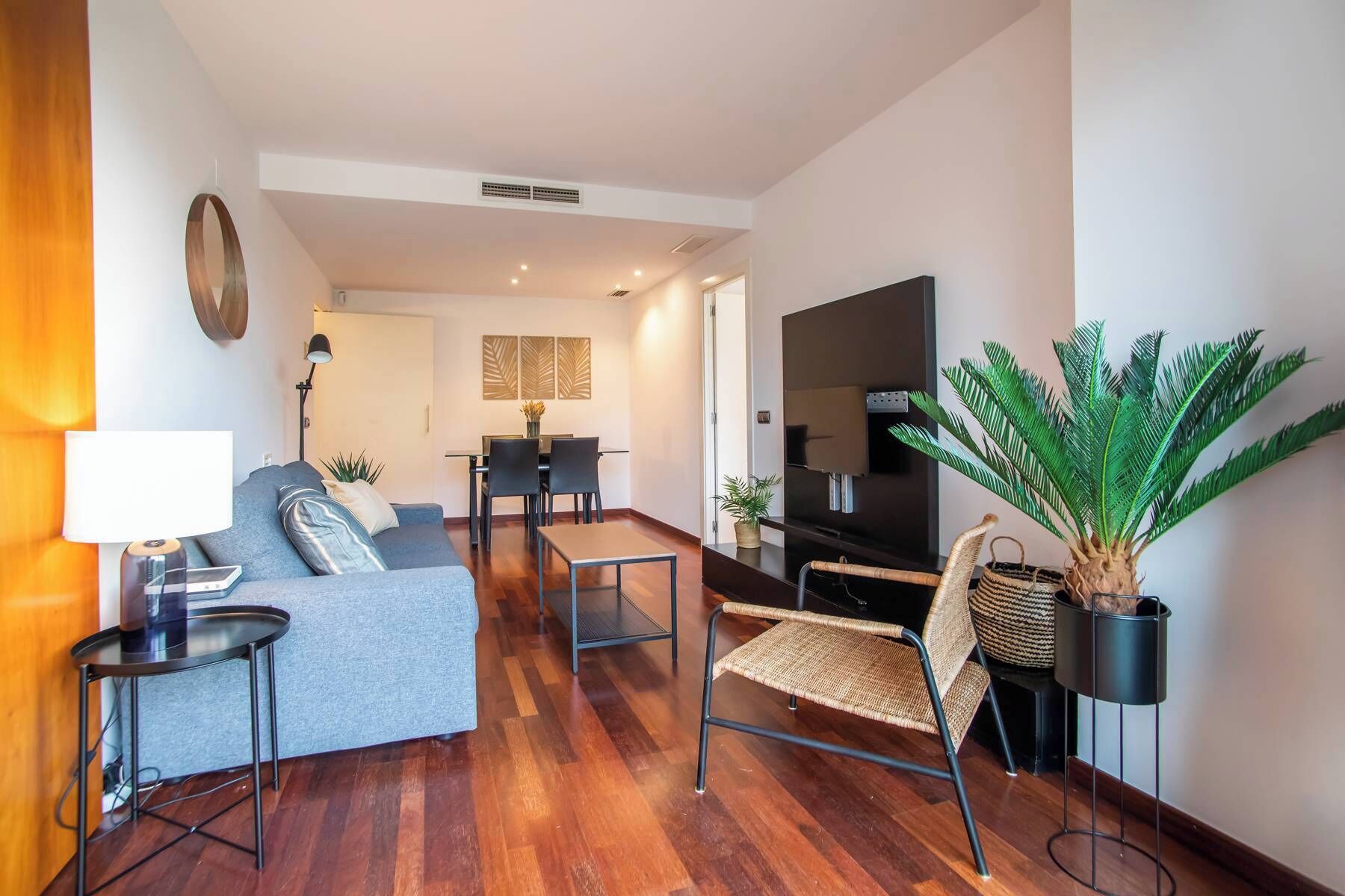 Een moderne woonkamer met een bank, een eettafel en een televisie.