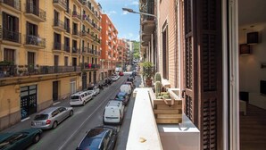 A street view with multi-story buildings, parked cars, and a narrow sidewalk. - P2VIIV1042  - Modern & Cozy Apartment Poble Sec (Barcelona)