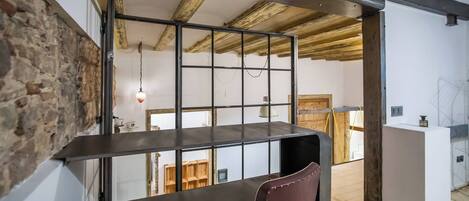 Un interior moderno con techo de madera, ventana de estructura metálica, una mesa de comedor y una silla.