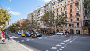 A street with multi-story buildings, a pedestrian crossing, and a cyclist. - 12par1003- Luminoso piso en Paralelo (Barcelona)