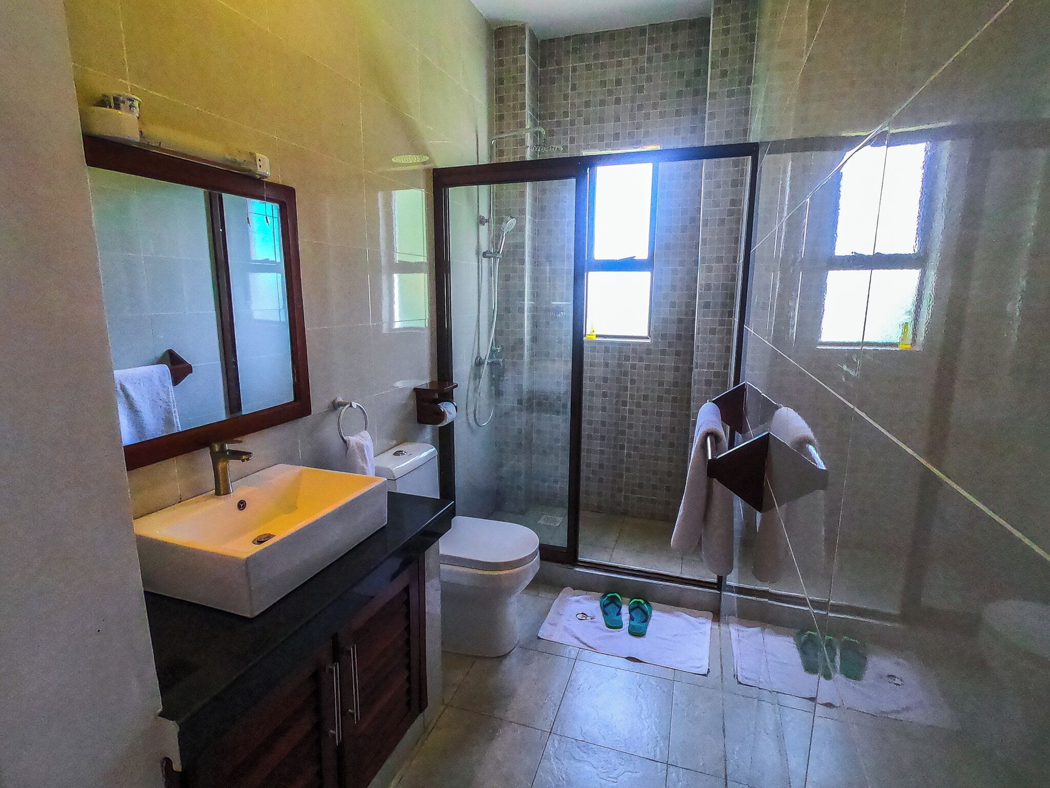 A bathroom with a sink, toilet, and glass-enclosed shower.
