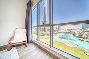 A room with a large window offering a view of a city skyline and a river.