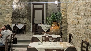 A restaurant with stone walls and tables set for dining. - Palazzo Iaquinta - Rooms & Restaurant (Cicerale)
