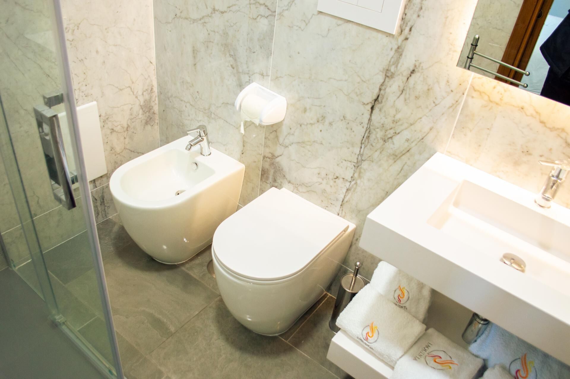 Un baño moderno con bidé, inodoro y lavamanos.